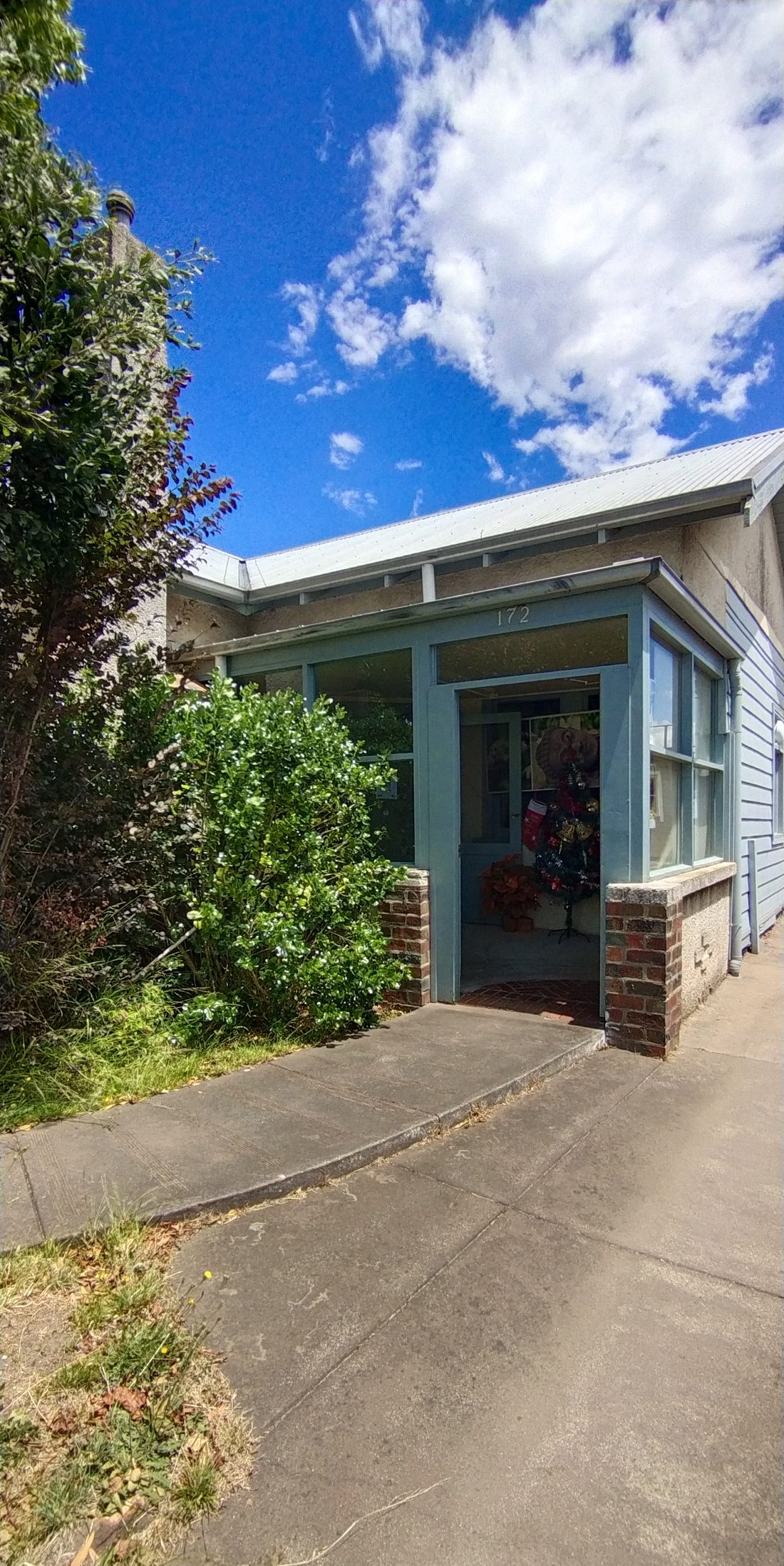 The front porch at 172 Albert Street with its duck-egg blue timber and brick base