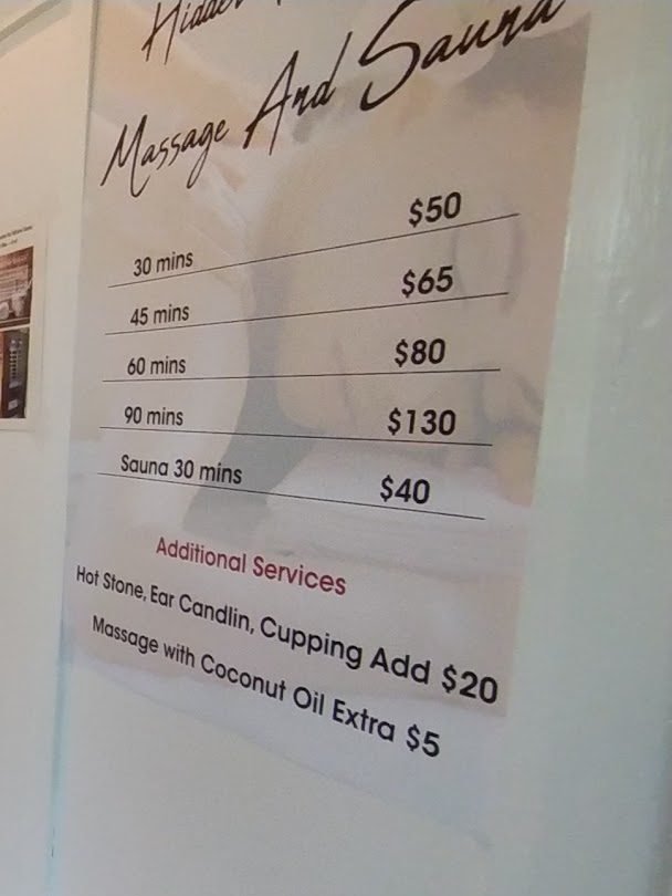 The Massage And Sauna price list on the wall inside the spa